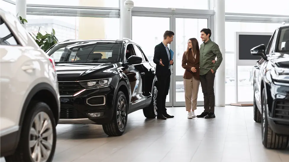 Happy couple shopping at a dealership show room